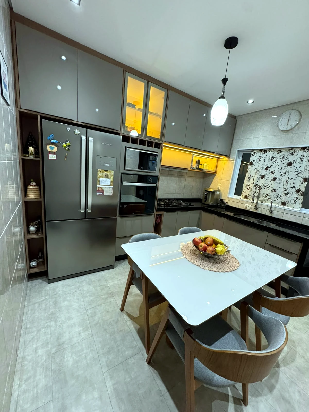 Cozinha planejada premium com iluminação, mesa central e armários sofisticados